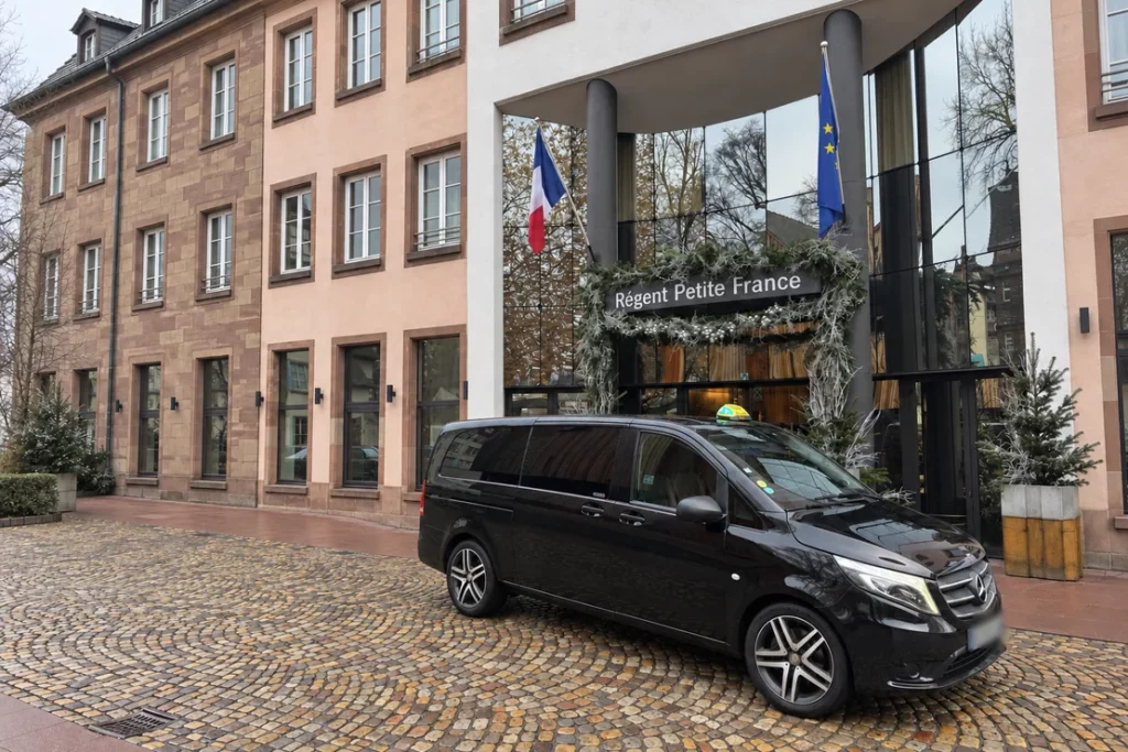Van Mercedes taxi devant l’entrée de l’hôtel Régent Petite France.