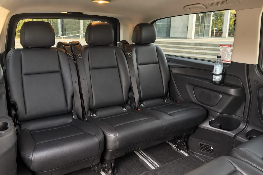Banquette noire à trois places dans l’habitacle du van Mercedes.