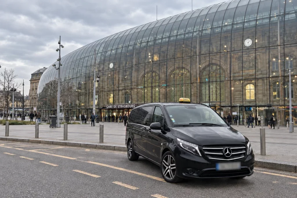 Van Mercedes taxi devant la verrière de la gare de Strasbourg.